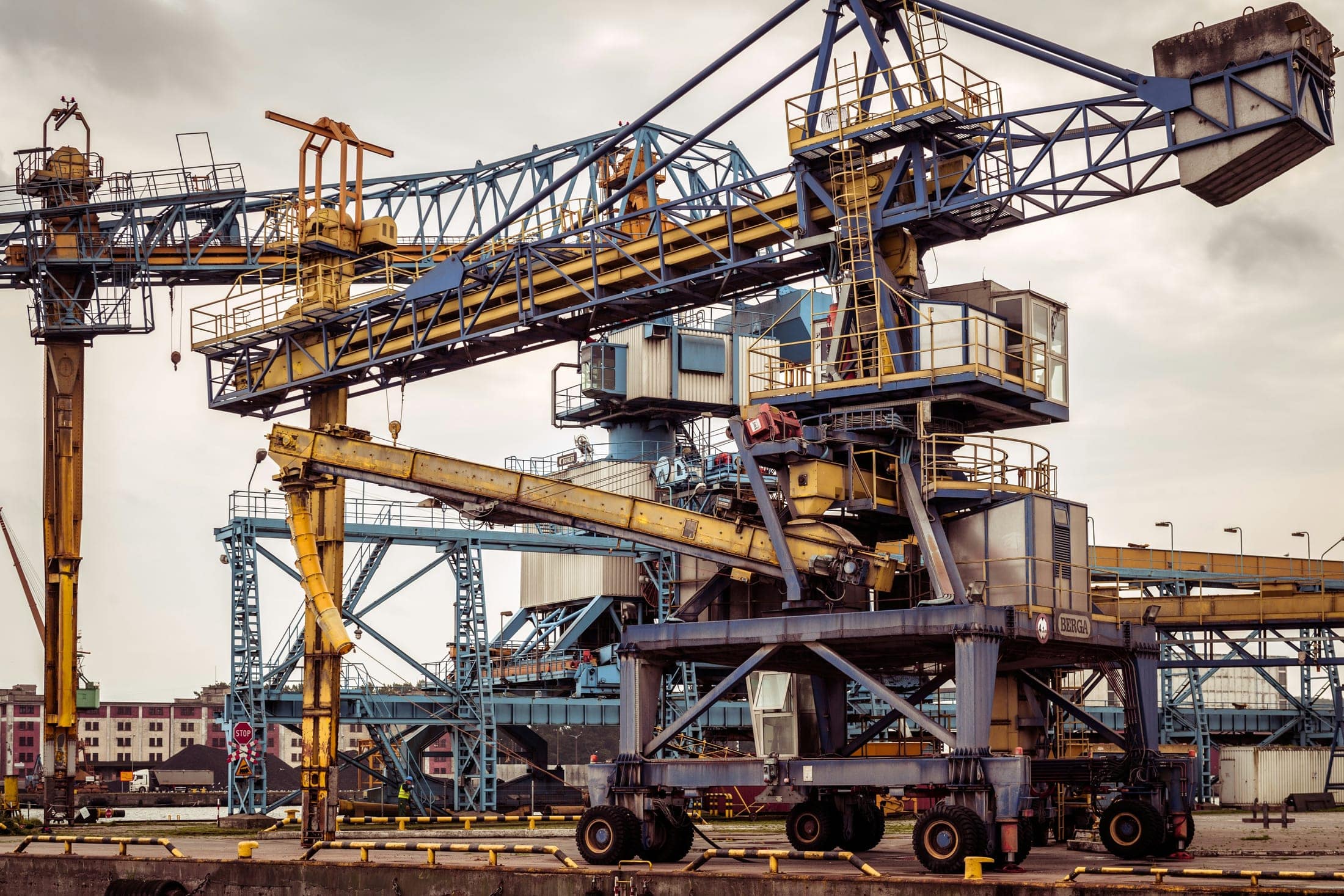 Heavy bulk-handling cranes and conveyor structures at an industrial port facility