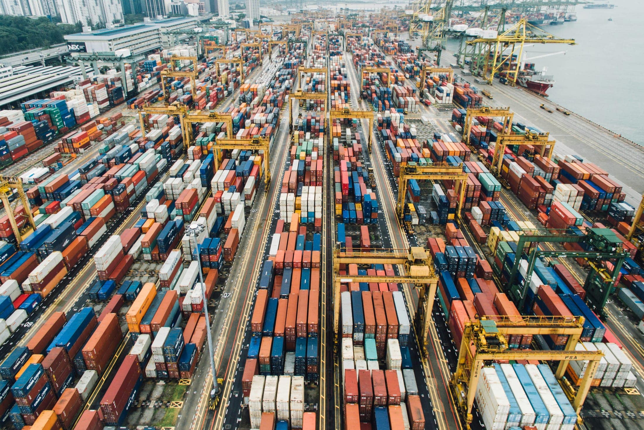Aerial view of shipping containers and gantry cranes at a container port